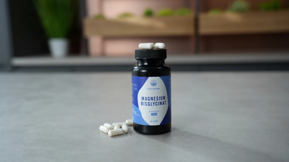 Die True Nature Magnesium Kapseln mit Bisglycinat neben einigen herausgenommenen Kapseln.